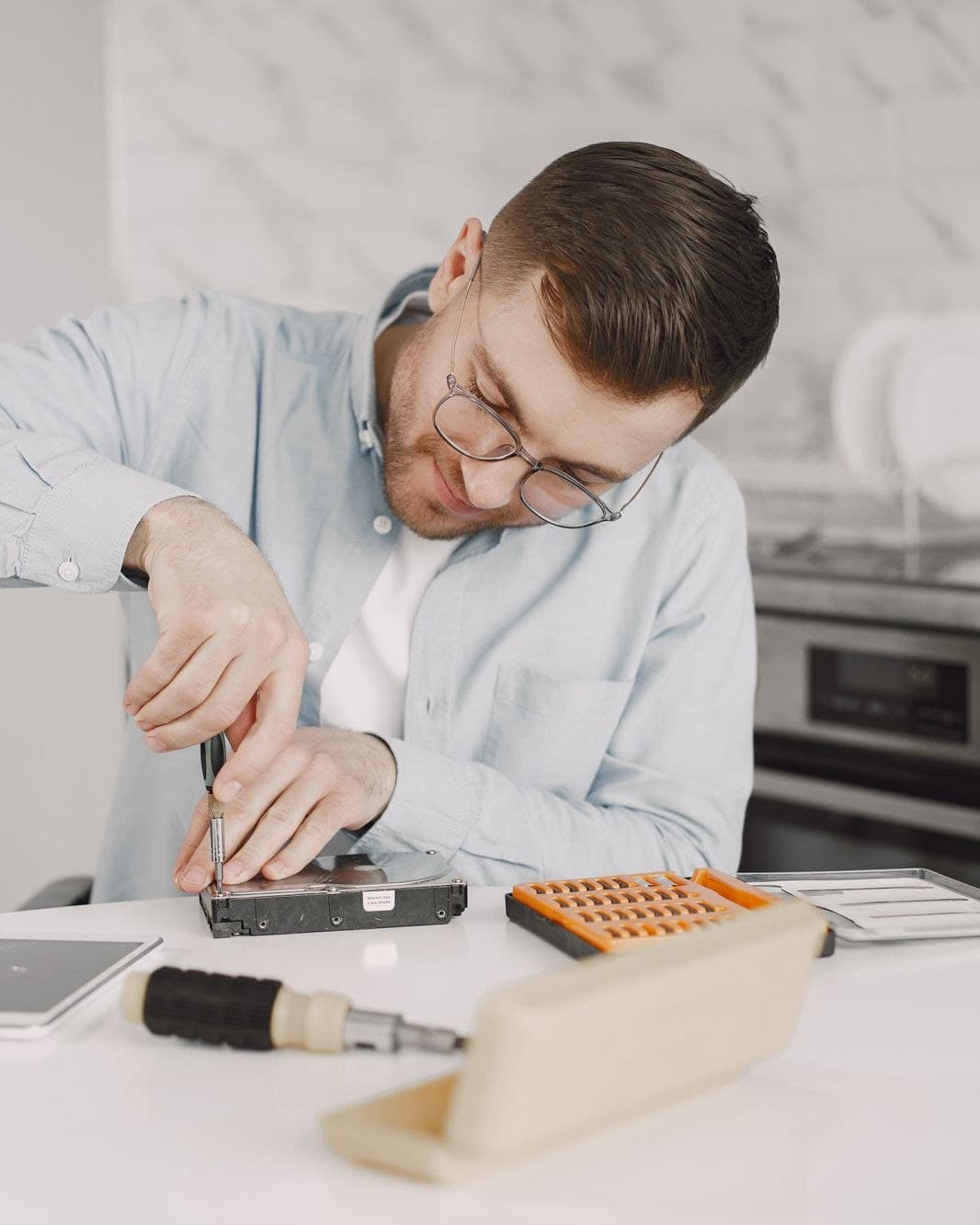 FixFirst Appliance Repair technician using a precision screwdriver to service a home appliance component at a kitchen worktable in Waco, TX